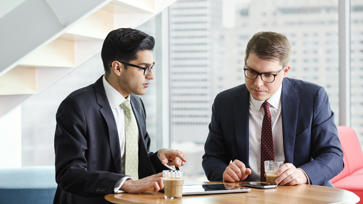 Two men working together with their mobile devices